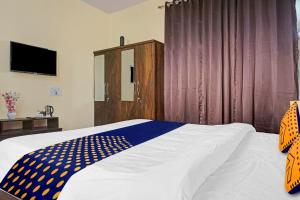 a bedroom with a bed with a blue and white comforter at OYO MYRA SERVICED APARTMENTS in Lohogaon