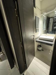 a bathroom with a sink and a shower stall at Freddy's Deluxe Family Apartments in Islamabad