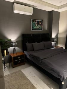 a bedroom with a bed with a black headboard at Freddy's Deluxe Family Apartments in Islamabad