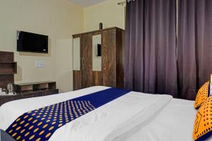 a bedroom with a bed with a blue and white comforter at OYO MYRA SERVICED APARTMENTS in Lohogaon