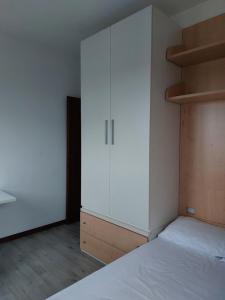 a bedroom with a white cabinet and a bed at #Punto FM 2# in Marghera