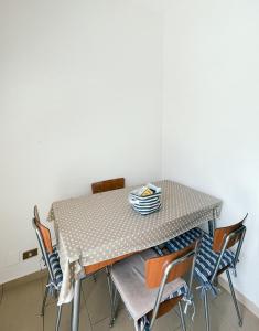 a dining room table with chairs and a white wall at delizioso appartamento a due passi dal mare in Catanzaro Lido