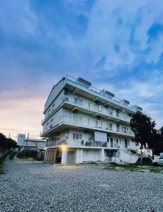 a white apartment building on a gravel lot at delizioso appartamento a due passi dal mare in Catanzaro Lido