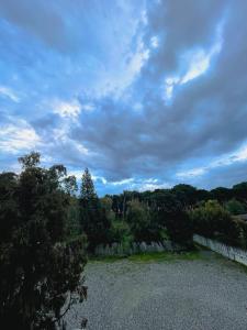 a cloudy sky with trees and a gravel road at delizioso appartamento a due passi dal mare in Catanzaro Lido