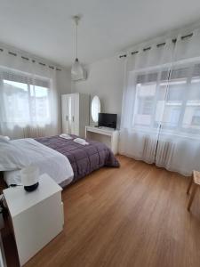 a white bedroom with a large bed and windows at Casa vacanze Omero in San Salvo