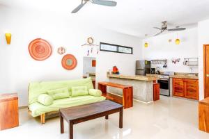 a living room with a couch and a kitchen at Stay in the Heart of Tulum l best location in Town in Tulum