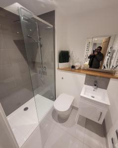 a man taking a picture of a bathroom with a toilet and shower at Luxury 2 Bed Apartment In The Heart Of Rochester in Rochester