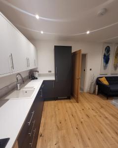 uma cozinha com balcões brancos e uma porta preta em Luxury 2 Bed Apartment In The Heart Of Rochester em Rochester