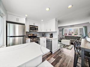 uma cozinha com armários brancos e electrodomésticos de aço inoxidável em Beautiful Home In Manahawkin With 3 Bedrooms And Wifi em Manahawkin