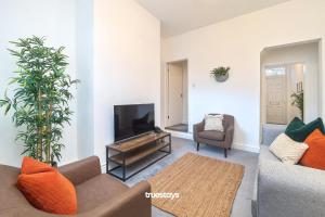 uma sala de estar com um sofá e uma televisão de ecrã plano em Penkhull House by Truestays - 4 Bedroom House in Stoke-on-Trent em Stoke-on-Trent