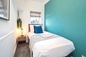 um quarto com uma cama grande e uma parede azul em Penkhull House by Truestays - 4 Bedroom House in Stoke-on-Trent em Stoke-on-Trent