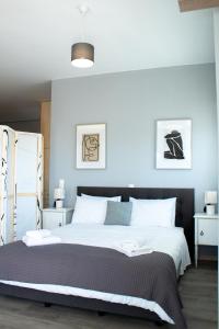 una camera da letto con un grande letto con pareti blu di EMVI APARTMENTS IV seaview near airport a Artemida