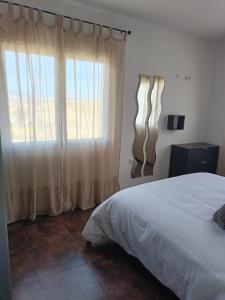 a bedroom with a bed and a large window at La Casa de Maia in Freila