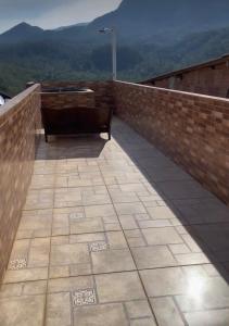 een balkon met een bank op een bakstenen muur bij Casa baiana in Itatiaia