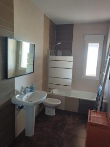 a bathroom with a sink and a toilet and a mirror at La Casa de Maia in Freila