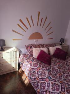 a bedroom with a bed with a sun on the wall at La Casa de Maia in Freila