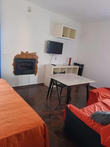 a room with a table and a tv and a desk at La Casa de Maia in Freila
