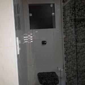 La salle de bains est pourvue d'une douche, de toilettes et d'une fenêtre. dans l'établissement Casa baiana, à Itatiaia