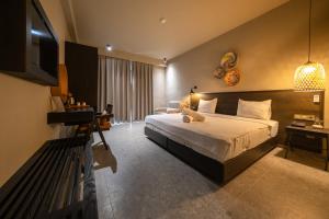 una camera d'albergo con un letto e una televisione di Kotinos Beach Hotel a Gokceada Town Altre 47 foto