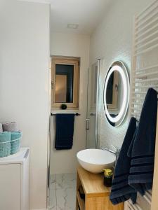 Baño blanco con lavabo y espejo en Apartman N&N en Koprivnica