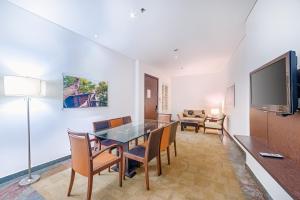 a living room with a table and chairs and a tv at Hotel Spiwak Chipichape Cali in Cali