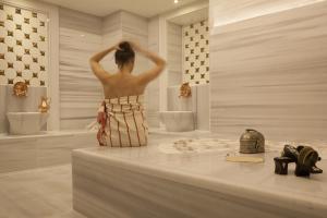 a woman taking a picture of herself in a bathroom mirror at The Bank Hotel Istanbul, a Member of Design Hotels in Istanbul