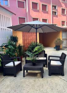 un patio con mesa, sillas y sombrilla en Apartamento Centroplaya, en Bueu