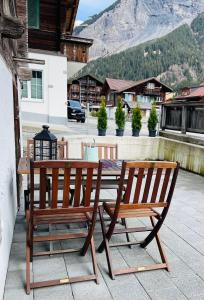 una mesa de madera y un banco en un patio en Charming, well-equipped Alpine apartment en Kandersteg