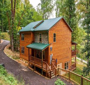 a wooden cabin in the woods with a fence at Heavenly Heights by Ghosal Luxury Lodging in Sevierville