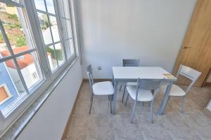 a table and chairs in a room with windows at Apartamentos Camelle in Camelle