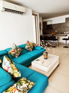 uma sala de estar com um sofá azul e uma mesa em Palmetto Beach Cartagena vista de frente al mar em Cartagena de Indias