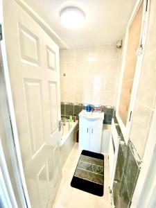 ein Badezimmer mit einer weißen Tür und einem Waschbecken in der Unterkunft Comfy Two bedroom Flat Edgeware Road In Central London in London