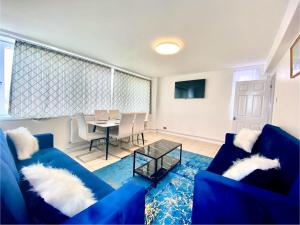 ein Wohnzimmer mit einem blauen Sofa und einem Tisch in der Unterkunft Comfy Two bedroom Flat Edgeware Road In Central London in London