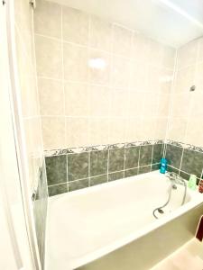 Das Bad ist mit einer Badewanne und einer Dusche ausgestattet. in der Unterkunft Comfy Two bedroom Flat Edgeware Road In Central London in London