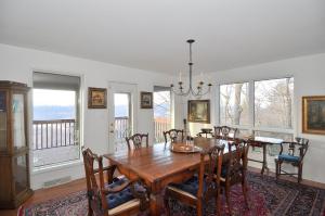 a dining room with a wooden table and chairs at Panorama Peak View- Wifi, Screen Porch, Million Dollar View, Fireplace, Full Kitchen in Berkeley Springs