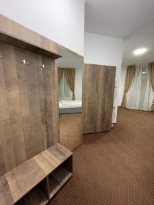 a large room with wooden doors and a room with a bed at Resedinta Cina in Braşov