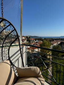 a balcony with a couch and a view of a city at Sea & Mountain Apartment in Lávrion
