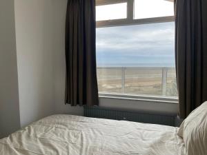 een slaapkamer met een bed en een raam met uitzicht bij apartment with sea view in Zandvoort