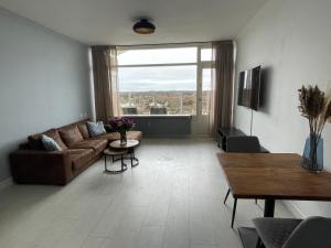 een woonkamer met een bank en een tafel bij apartment with sea view in Zandvoort