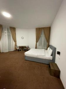 Un dormitorio con una cama y una mesa. en Resedinta Cina, en Brasov