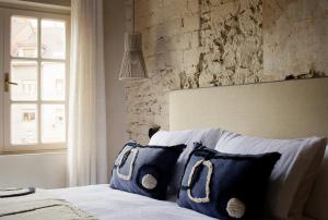 een slaapkamer met een bed met blauwe kussens en een raam bij APARTAMENTO DISEÑo GALIANA 6 ARENA AVILÉS ASTURIAS in Avilés