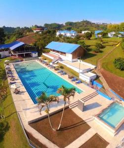 uitzicht op een groot zwembad met palmbomen bij Hotel Villa Mónaco in Pereira
