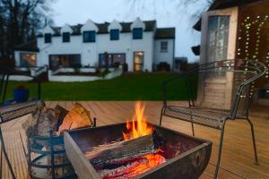 a fire pit in a yard with a house in the background at Kinkell House B&B in Cononbridge