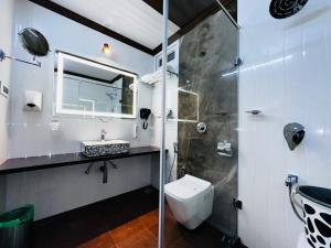 a bathroom with a shower and a toilet and a sink at Beverly villa in Ooty