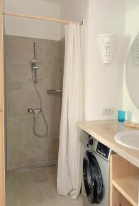 a shower in a bathroom with a washing machine at Lagoon Apartment in Dahab