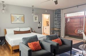 ein Schlafzimmer mit einem Bett und zwei Stühlen in der Unterkunft LA Huge Mid Century Guesthouse Patio LAX Beach in Los Angeles + 43 Fotos