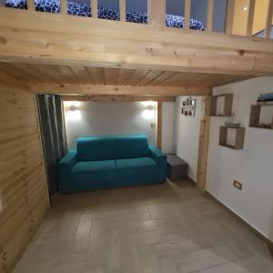 uma sala de estar com um sofá azul debaixo de um loft em Sole mare vacanze em Crotone