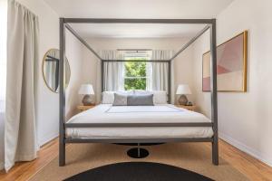 a bedroom with a canopy bed and a window at Culver City 1920s Bungalow on Shady Cul-du-Sac in Los Angeles