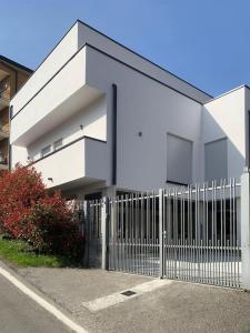 un edificio bianco con una recinzione di fronte di Green Home - Bellagio Apt a Como