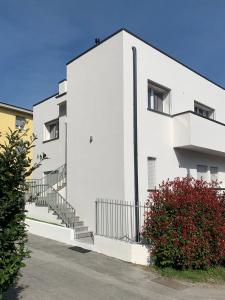 - un bâtiment blanc avec des escaliers sur son côté dans l'établissement Green Home - Bellagio Apt, à Côme